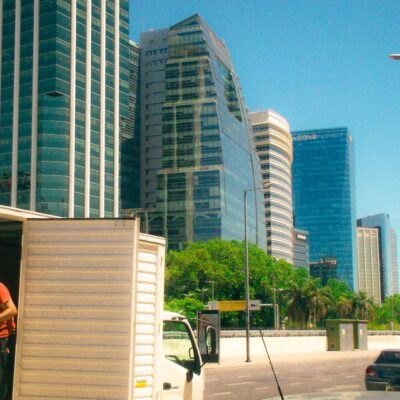 Urban scene in Buenos Aires with skyscrapers and delivery activity on a sunny day.