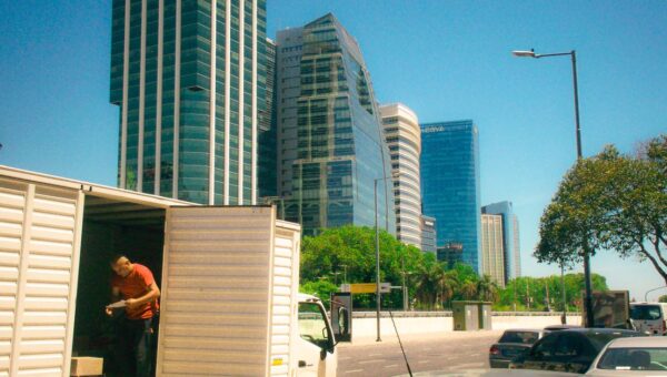 Urban scene in Buenos Aires with skyscrapers and delivery activity on a sunny day.