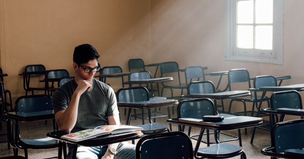 A person studies alone in an empty classroom with sunlight streaming through the window in Buenos Aires.