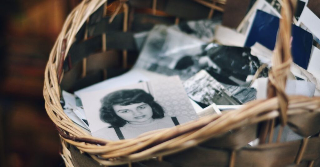 A collection of vintage black and white photos in a woven basket evokes nostalgia.