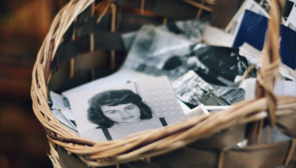 A collection of vintage black and white photos in a woven basket evokes nostalgia.