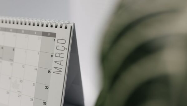 A close-up shot of a desk calendar open on March, with a soft, minimalistic background.