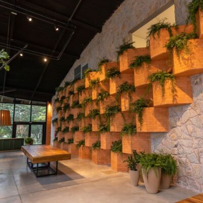 A spacious restaurant interior featuring brick wall design and indoor plants for a natural ambiance.
