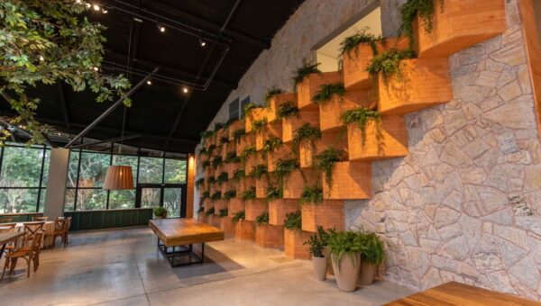 A spacious restaurant interior featuring brick wall design and indoor plants for a natural ambiance.