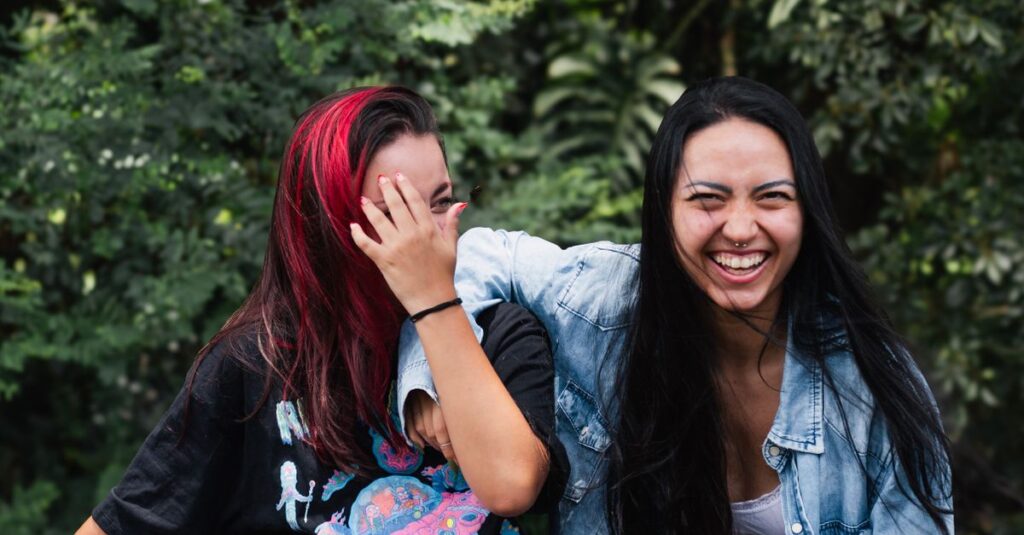 Two young women share a joyful moment outdoors, showcasing friendship and happiness.