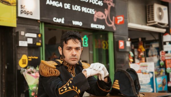 A man in a naval uniform poses at an outdoor cafe in Buenos Aires, Argentina.