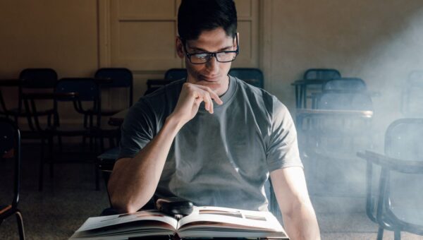 Student reading a book in a sunlit classroom in Buenos Aires. Perfect for educational themes.
