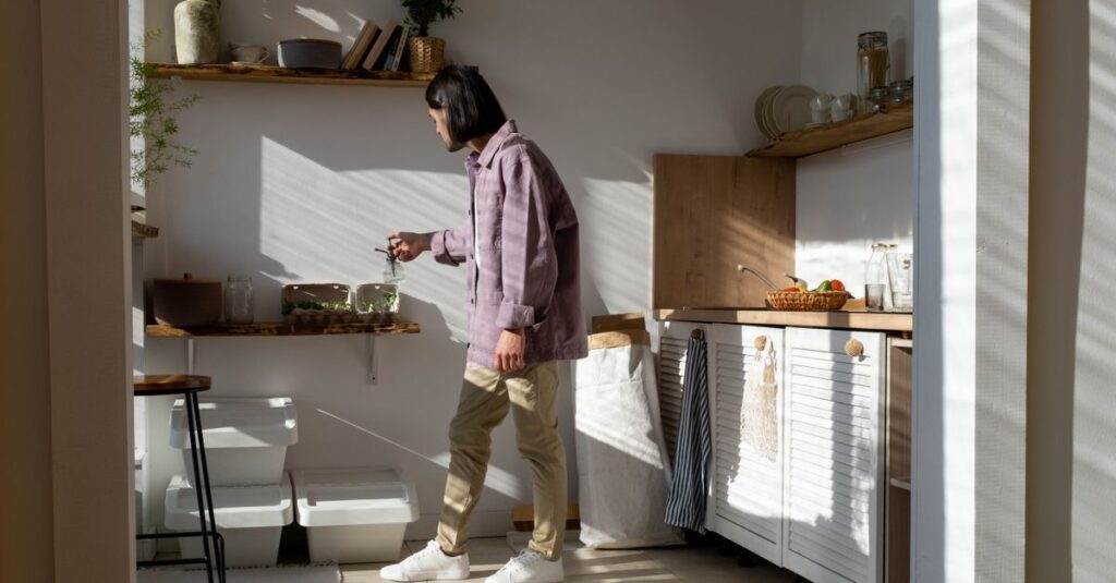 5 Dicas para Criar um Estilo de Vida Sustentável e Acessível 2 Man in casual wear tending to indoor plants in a sunlit kitchen.