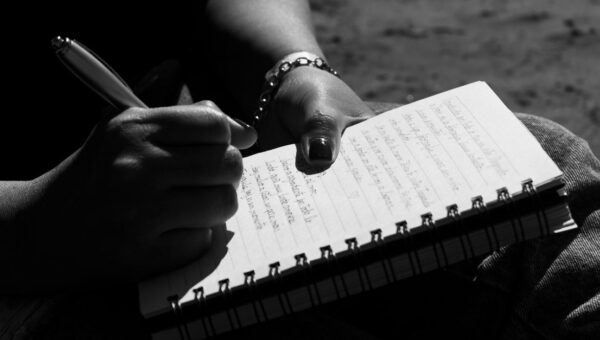 Close-up of a person writing in a notebook, captured in Mar del Plata, Argentina.