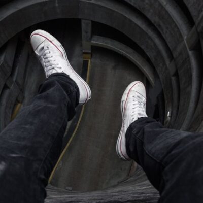 View from above looking down into a circular structure with legs in black jeans and white shoes.