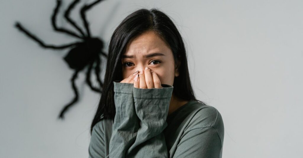 Como Transformar o Medo em Força: Dicas Práticas para Mulheres 2 An anxious woman indoors with a large wall spider, depicting arachnophobia.
