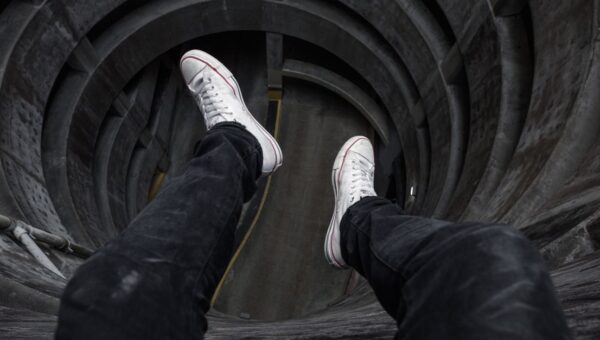 View from above looking down into a circular structure with legs in black jeans and white shoes.