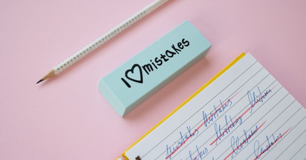 Como Superar o Perfeccionismo e Viver com Leveza 2 A blue eraser with 'I Love Mistakes' next to a pencil and crossed-out text on a pink background.