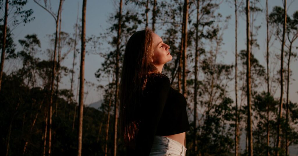 Como Lidar com a Ansiedade e Encontrar a Paz Interior 2 Portrait of a woman enjoying nature and freedom in a forest setting.