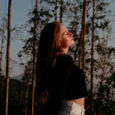 Portrait of a woman enjoying nature and freedom in a forest setting.
