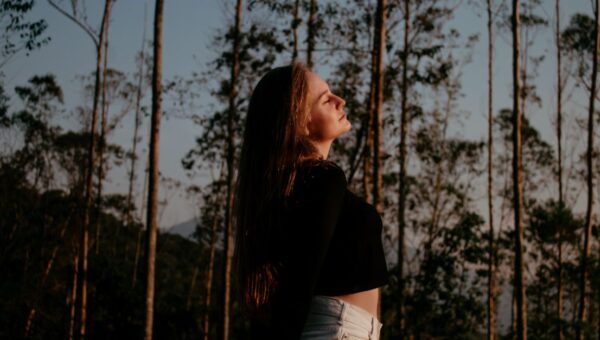 Portrait of a woman enjoying nature and freedom in a forest setting.
