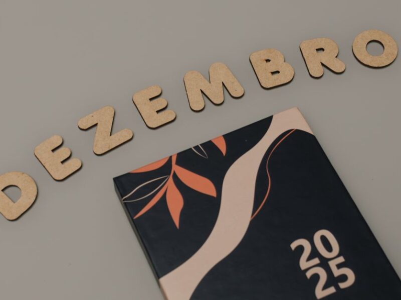 A minimalist 2025 calendar with cork letters spelling 'DEZEMBRO' on a neutral background.