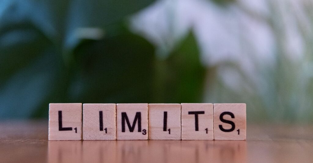 Como Estabelecer Limites Saudáveis em Relacionamentos 2 Wooden letter tiles forming the word 'LIMITS' on a wooden table.