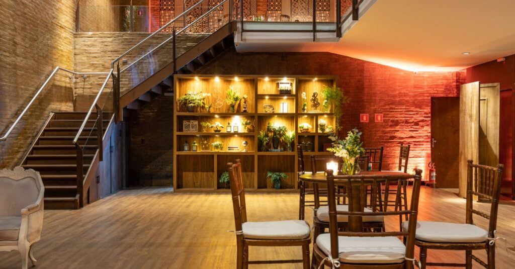 An elegant modern lounge with an illuminated staircase and stylish indoor plants.
