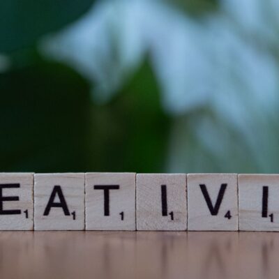Scrabble tiles spelling 'CREATIVITY' with a blurred green background.