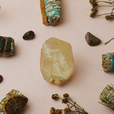 Healing crystals and herbs arranged on a soft background for a spiritual ambiance and meditation setup.