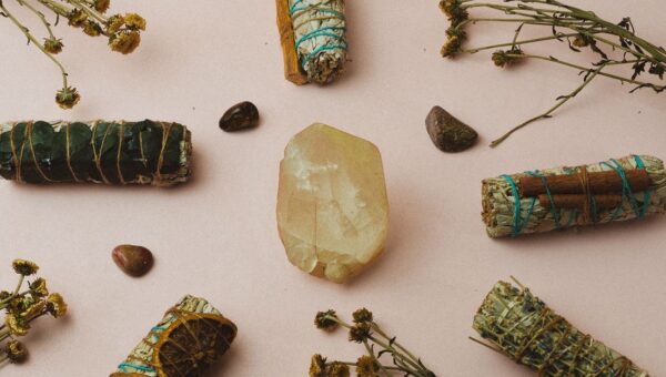 Healing crystals and herbs arranged on a soft background for a spiritual ambiance and meditation setup.