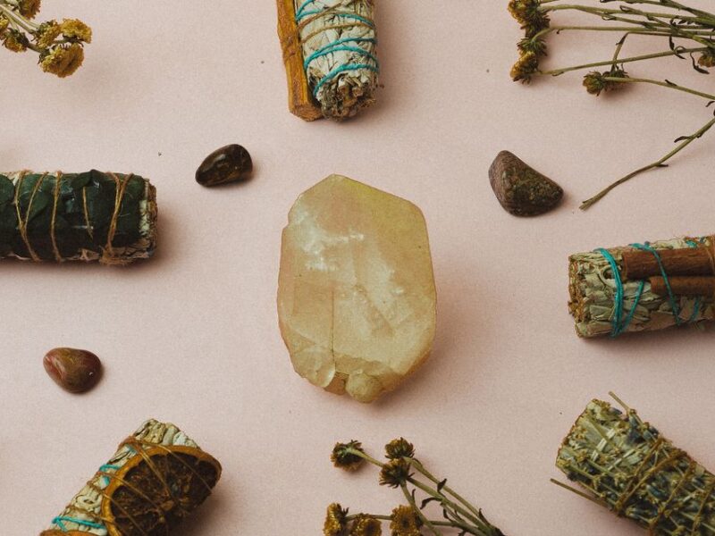 Healing crystals and herbs arranged on a soft background for a spiritual ambiance and meditation setup.