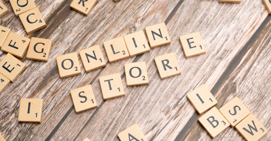 Como a Criatividade Pode Melhorar seu Autocuidado Diário 2 Scrabble tiles spelling 'online store' on a rustic wooden background.