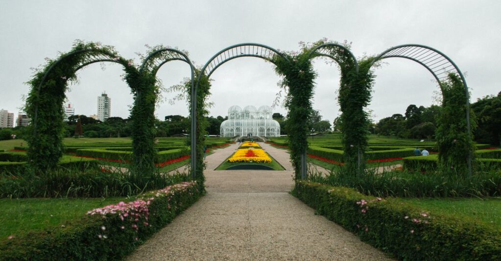 Beautiful garden with arches and vibrant flowers in a city park setting.