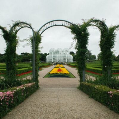 Beautiful garden with arches and vibrant flowers in a city park setting.
