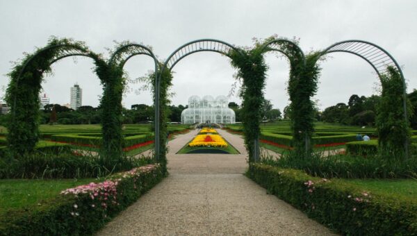 Beautiful garden with arches and vibrant flowers in a city park setting.