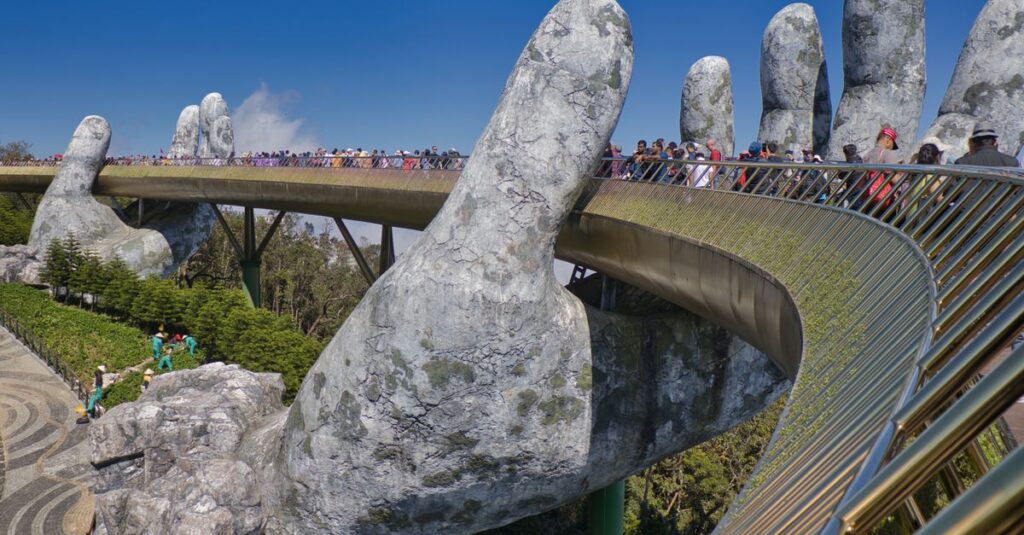 Como a Criatividade Pode Transformar sua Alimentação Saudável 2 The iconic Golden Bridge with giant hand sculptures at Ba Na Hills, Vietnam, under a clear blue sky.